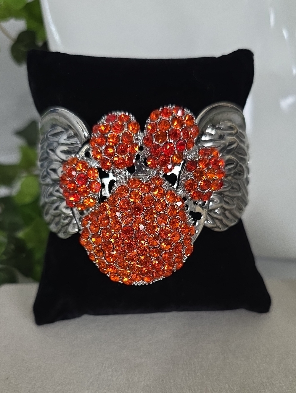 Silver Tone Winged Paw Print Cuff Bracelet with Vibrant Orange Rhinestones